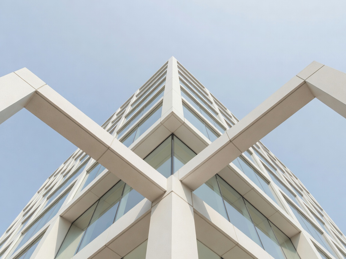 Architectural photograph looking up at the geometric lines of a pale modern building.